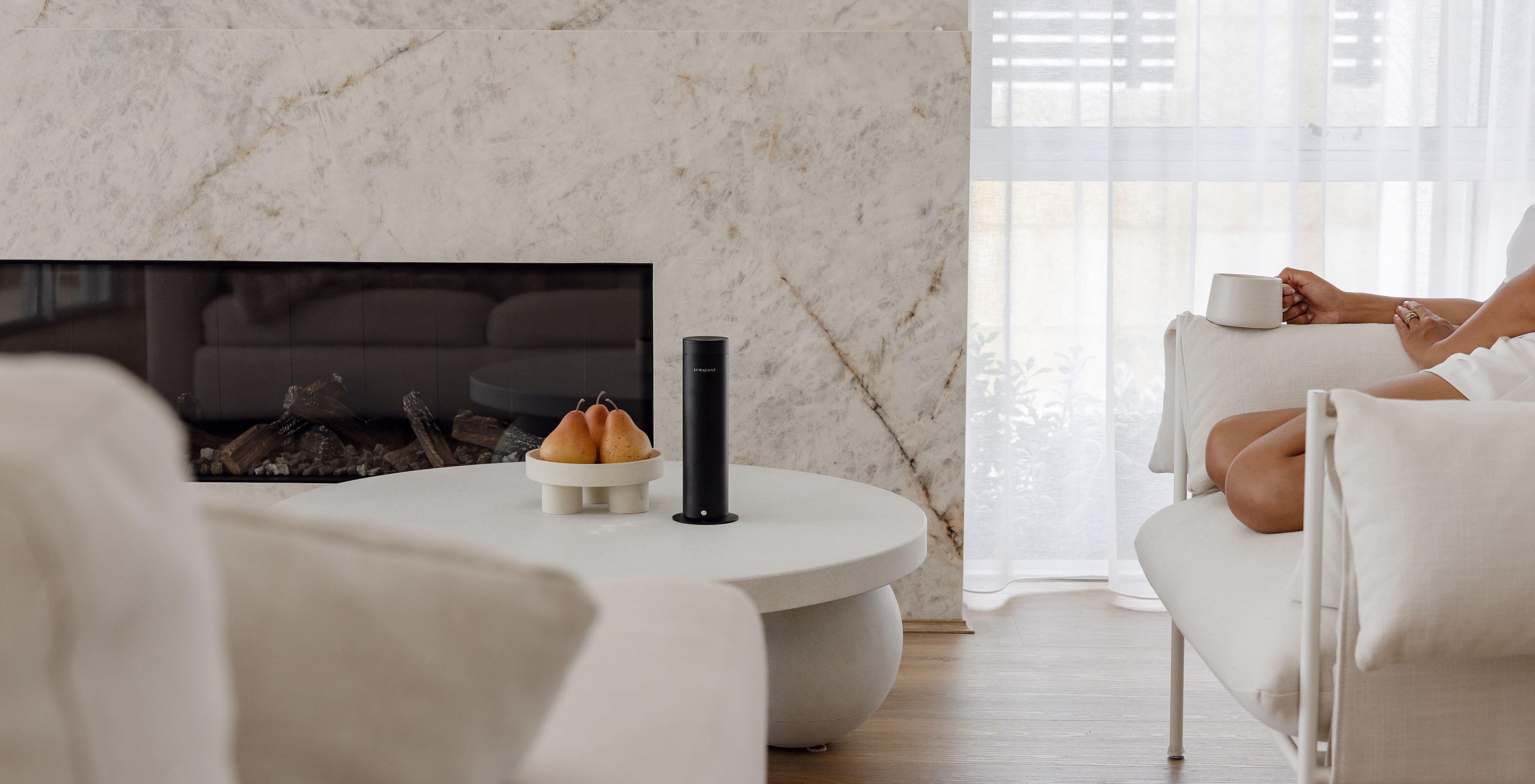 Modern living room with marble fireplace, white sofa, and coffee table.