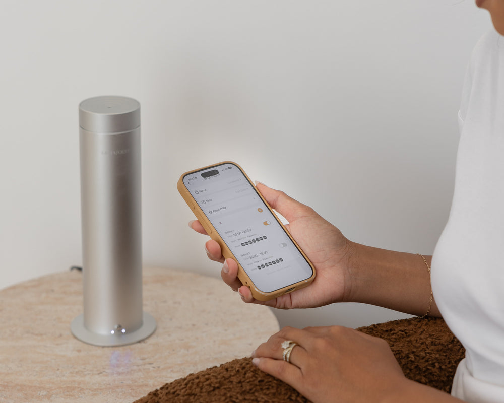 Person using a smartphone app with a cylindrical device on a white background